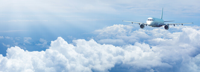 Jet plane in a blue cloudy sky. © Kornienko Alexandr