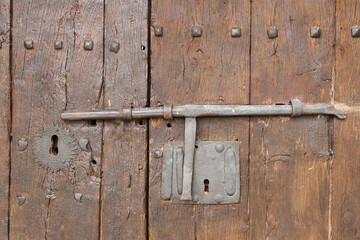Old metal bolt on a wooden door in a romanesque church in Pisón de Castrejón, north of Palencia, Spain