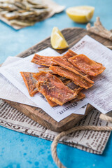 Snacks for beer. Dried codfish fillet on wooden background. Snack for beer dried smelts.