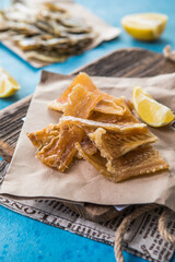 Snacks for beer. Dried codfish fillet on wooden background. Snack for beer dried smelts.