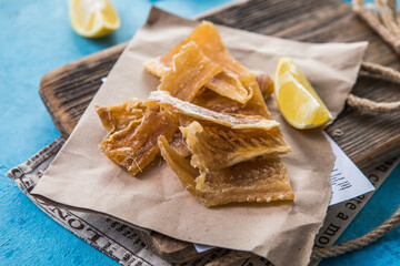 Snacks for beer. Dried codfish fillet on wooden background. Snack for beer dried smelts.