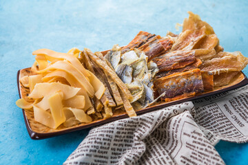 Dried Seafood Mix with Squid, Tuna, codfishon, yellow minke on Plate Top View. Cured Dehydrated Fish Fillet as Beer Snack