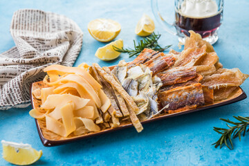 Dried Seafood Mix with Squid, Tuna, codfishon, yellow minke on Plate Top View. Cured Dehydrated Fish Fillet as Beer Snack