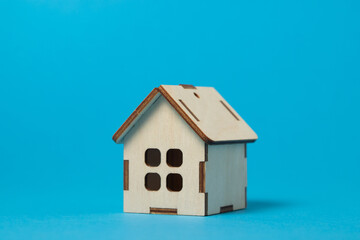 Fototapeta na wymiar Wooden small house on a blue background. Real estate purchase and sale concept. Real estate services