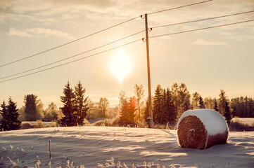 Scenic view of haystacks, winter sunset in the countryside