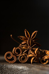 Traditional Christmas spices - Star anise with cinnamon sticks on dark rustic wooden background, macro close up view. Copy space.