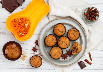 Freshly baked homemade pumpkin muffins with chocolate and spices (cinnamon, star anise, cardamom). Healthy homemade cakes for breakfast. Selective focus, top view