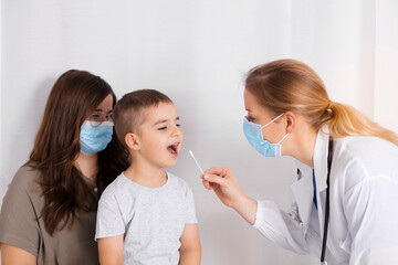Covid 19 test by child. Doctor or nurse testing little boy for coronavirus using mouth swab method....