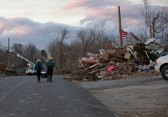 An Amish father and son off food and drinks as they walk through a tornado destroyed subdivision in...