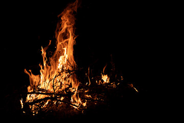 A fire is burning at night. Fine branches on fire. Lighting the fire.