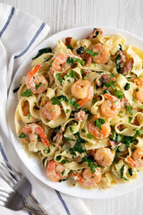 Homemade Shrimp Spinach Bacon Alfredo on a Plate, top view. Flat lay, overhead, from above.