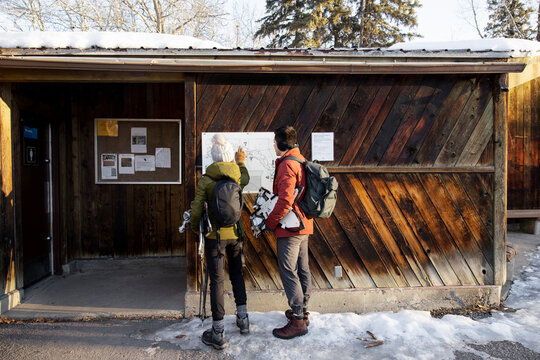 Hikers looking at information board on hut