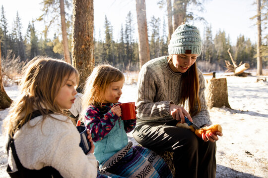 Family having winter picnic in snowy forest
