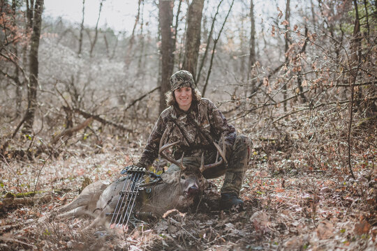 Teen boy holding up his successful 8 point buck hunt with a bow
