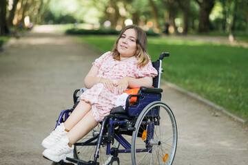 Young caucasian woman with disability enjoying fresh air at green city park. Female wheelchair user...