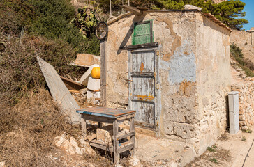 Fototapeta na wymiar Old abandoned stone house on the coast of the mediterranean sea on the island Levanzo in Sicily, province of Trapany, Italy.