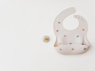 Silicone bib with on neutral background. Top view, flat lay, baby serving first food
