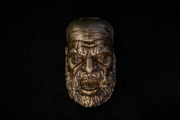 The figure of a bearded screaming man made of bronze