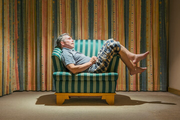An elderly tourist dozed off in a chair in an inexpensive hotel - obrazy, fototapety, plakaty