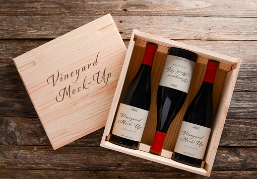 3 Red Wine Bottles in a Wood Crate on a Wooden Background