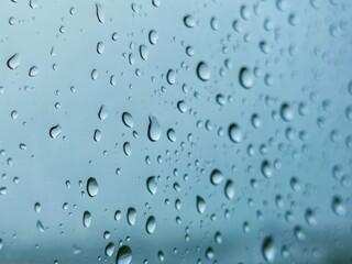 Rainwater drops on blue glass
