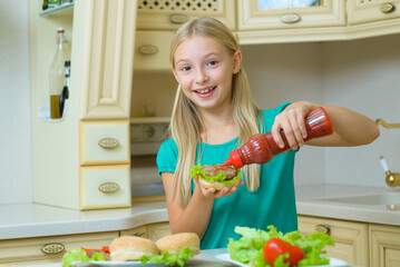 A teenage child with a beautiful, charming smile made a fresh vegetable sandwich
