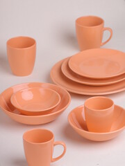 set of orange ceramic dishes on a light background