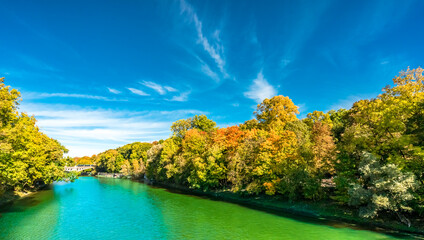View on Isar river an colorful trees in autumn landscape in Munich