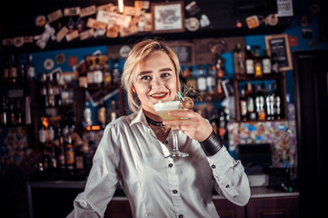 Girl bartender concocts a cocktail on the bar