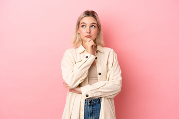 Young caucasian woman isolated on pink background thinking an idea while looking up