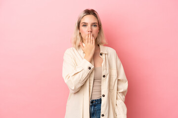 Young caucasian woman isolated on pink background covering mouth with hand