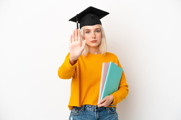 Young university caucasian woman graduate isolated on white background making stop gesture