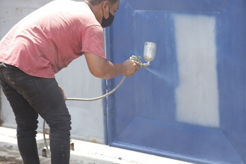 workers are painting using spray paint