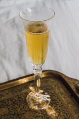 flute glass of champagne sparkling wine on Indian brass tray