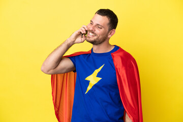 Super Hero Brazilian man isolated on yellow background keeping a conversation with the mobile phone © luismolinero