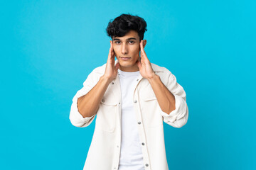 Young Argentinian man isolated on background frustrated and covering ears