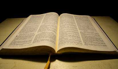 Fototapeta premium open bible reflected with warm light