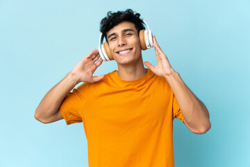 Young Argentinian man isolated on background listening music