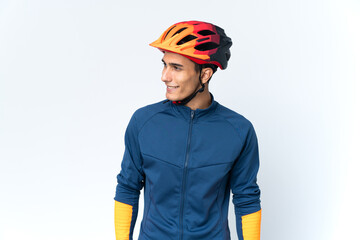 Young cyclist man isolated on background looking to the side and smiling