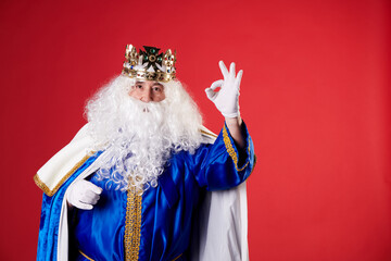 a Magician King making the Ok gesture on a red background