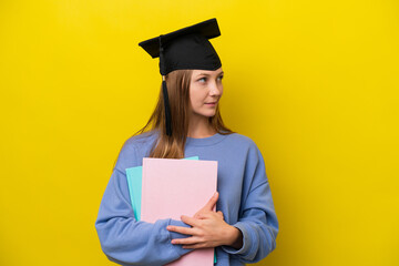 Young student Russian woman isolated on yellow background looking to the side