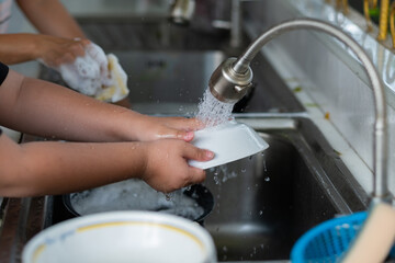 Close up hands washing dishes