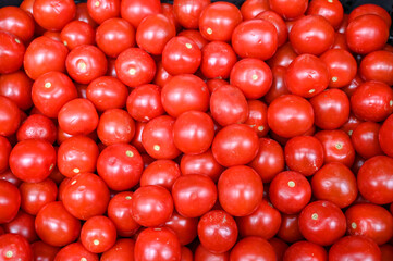 Red tomatoes for sale at vegetable market, close up. Boxes full of tomatoes in shop. Fresh tomato at the greengrocer's stall. Ripe tomatoes on table. Vegetable.