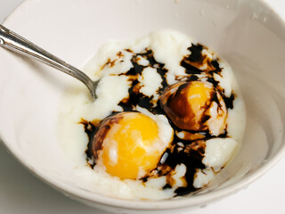 Delicious half boiled eggs in bowl with ketchup.