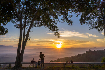 Fototapeta na wymiar beautiful yellow sunrise at the horizon of mountain range in phang Nga Thailand..A pilot flying a drone to shooting view of the mist in the valley..beautiful sunrise in the mist background.