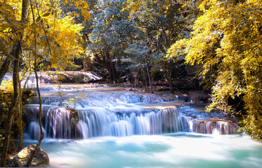 Erawan waterfalls in the national park mountains of Kanchanaburi BKK Bangkok Thailand lovely turquoise blue creamy waters lush green Autumn Leaves on trees smooth rock formations