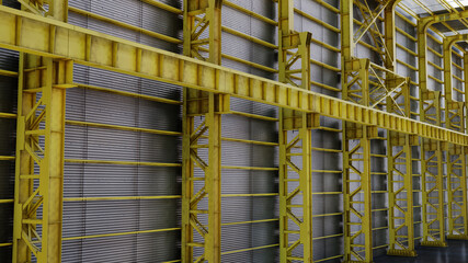 Factory shed with yellow steel beams with details of screws and cables and skylights for sunlight
