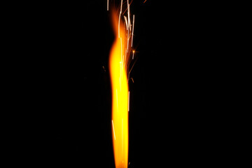 Close up of burning candle sparkler on black background