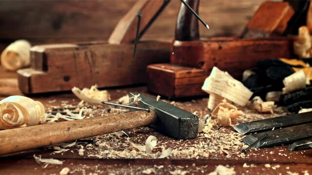 Nails fall on the table with a hammer. On a wooden background.Filmed is slow motion 1000 frames per second. High quality FullHD footage