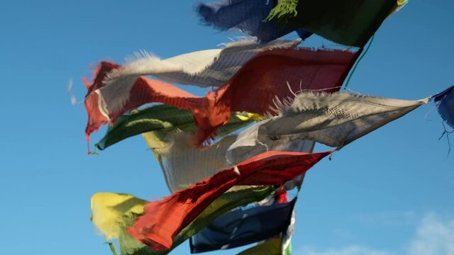 Religious tibetan buddhist prayer flags. Flags are flutter in the wind on blue sky background.  Altai,  Russia